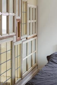 a set of glass windows in a room at Stijlvol & lief onthaast-huisje met piano, tv en wifi in Holwerd