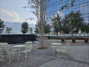 a group of tables and chairs in front of a building at A 7 Minutos de San Pedro Lujoso Penthouse in Monterrey