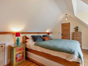 um quarto com uma cama e uma mesa com um candeeiro em 1 Bed in Barnstaple 93422 em Marwood