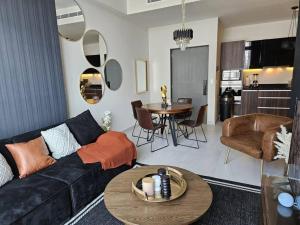 a living room with a black couch and a table at A 7 Minutos de San Pedro Lujoso Penthouse in Monterrey