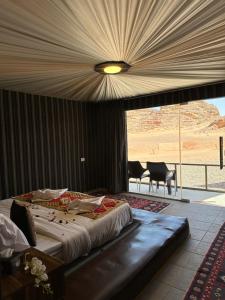 a bedroom with a large bed with a view of the desert at Sunset Gem _ Wadi Rum in Disah
