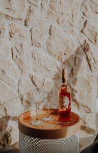 a bottle of whiskey and two wine glasses on a table at Lili Rose Mandre Luxury Apartments in Mandre