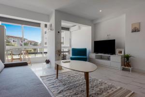 een woonkamer met een tafel en een televisie bij City apartment Puerto Banus in Marbella