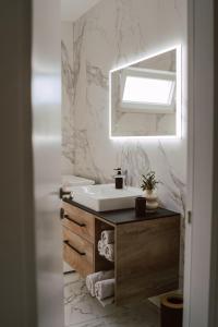 a bathroom with a sink and a mirror at Lili Rose Mandre Luxury Apartments in Mandre
