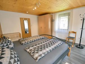 a bedroom with two beds and a chair at Landhaus Christina in Rumbach