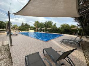 une piscine avec deux chaises et un parasol dans l'établissement Nissi Beach Escape - 5 Min Walk to Paradise, à Ayia Napa