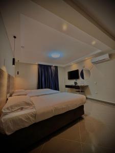 - une chambre avec un grand lit et une télévision dans l'établissement Ivory Park Hotel - Safari Waterworld, à Nakuru