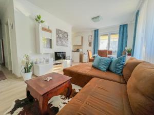 ein Wohnzimmer mit einem Sofa und einem Tisch in der Unterkunft Relax Prémium Wellness Apartman in Siófok