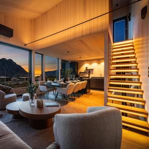ein Wohnzimmer mit einer Treppe, einem Tisch und Stühlen in der Unterkunft NEW! Spectacular cabin in Lofoten in Kleppstad