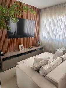 een woonkamer met een bank en een televisie bij Bella House in Luis Eduardo Magalhaes