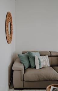 un sofá con almohadas en la sala de estar en Lili Rose Mandre Luxury Apartments en Mandre