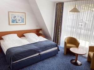 1 dormitorio con 1 cama, 1 silla y 1 ventana en Hotel Am Weißen Turm, en Bad Neuenahr-Ahrweiler