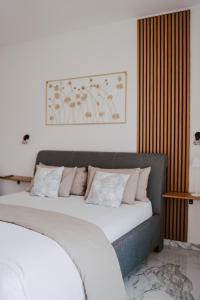 マンドレにあるLili Rose Mandre Luxury Apartmentsのベッドルーム1室(白いシーツとピンクの枕が備わるベッド1台付)