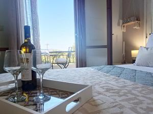 a bedroom with a bed with a bottle of wine and glasses at Villa Nova s.r Sea View in Porto Heli