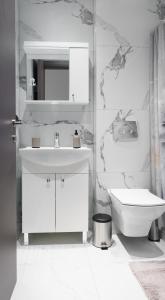 a white bathroom with a sink and a toilet at Studio D in Kallithea Halkidikis