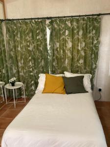 uma cama com duas almofadas amarelas num quarto em Casa rural con piscina / Cottage house with swimming pool em Elche