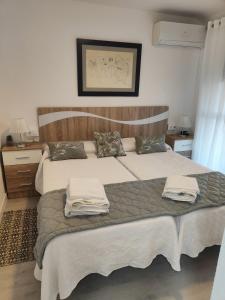 a bedroom with two beds with towels on them at Agradable Dúplex Terraza Virgen del Rocio in Seville