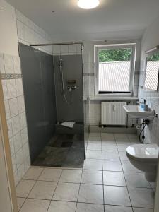 W łazience znajduje się prysznic i umywalka. w obiekcie Pharos zur Seeve w mieście Seevetal