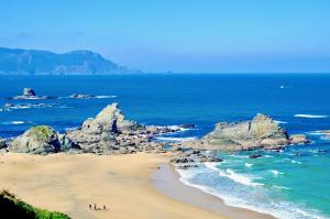 un grupo de personas en una playa cerca del océano en The Cliffs - ViveMare, en Viveiro