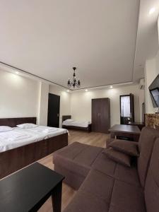 ein Hotelzimmer mit 2 Betten und einem Sofa in der Unterkunft Guest House Madonna in Kobuleti