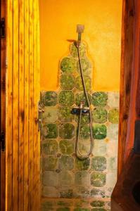 a bathroom with a shower in a stone wall at Auberge Kasbah Dar Sahara Tours in Mhamid