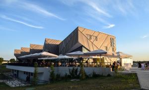 a building with tables and umbrellas in front of it at Goričko view house in Križevci