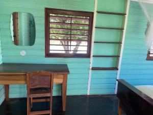 Habitación con escritorio de madera y ventana. en Dolphin Blue Paradise en Bocas del Toro