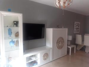 a white entertainment center with a flat screen tv at Casa Adosada in Bormujos