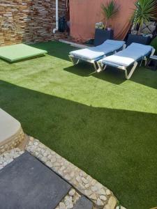 a backyard with two picnic tables and green grass at Casa Adosada in Bormujos