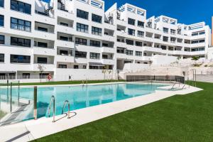 a swimming pool in front of a large apartment building at Casa Isa - Luxury Penthouse Seaview in Estepona