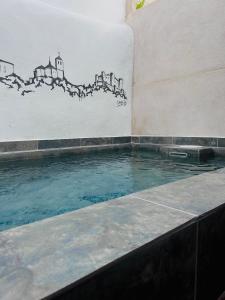 a swimming pool with a painting on the wall at Casa Rural La Simona in Belmonte