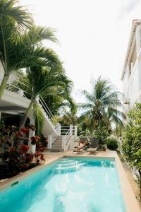 una piscina frente a un edificio con palmeras en Seremei Villas en Caye Caulker