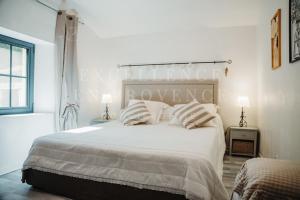 a white bedroom with a large bed with pillows at Mas de l'air in Noves +69 photos