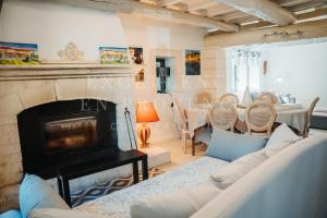 a living room with a fireplace and a table at Mas de l'air in Noves