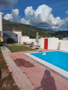 a swimming pool in a yard with a table at Neiras Apartments Blagaj in Blagaj