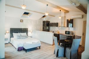 a bedroom with a bed and a table and a kitchen at Mas de l'air in Noves