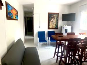 a dining room with a table and blue chairs at Playa Los Cocos Apat 2 y 3 in Santa Marta