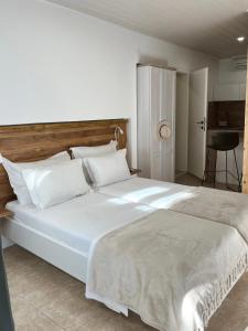 1 dormitorio con 1 cama blanca grande y almohadas blancas en Apartments Coco, en Hvar