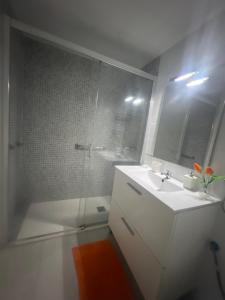 uma casa de banho branca com um lavatório e um chuveiro em Benylife em Benidorm
