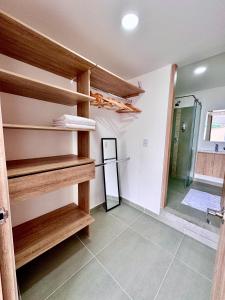 a room with wooden shelves in a room with a shower at Casa Turística en el Quindío in La Tebaida