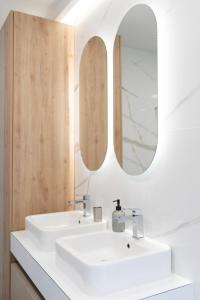 a bathroom with a white sink and two mirrors at Villa H in Blagaj