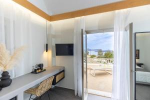 a room with a desk with a view of a balcony at William's Houses in Akrotiri