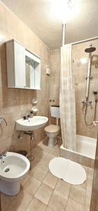ein Bad mit einem Waschbecken, einem WC und einer Dusche in der Unterkunft Apartments Ivana in Sutivan