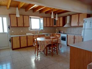 a kitchen with a table and chairs and a refrigerator at Castelo Chalet Chios in Chios