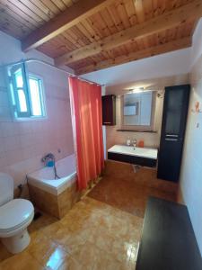 a bathroom with a toilet and a tub and a sink at Castelo Chalet Chios in Chios +22 photos