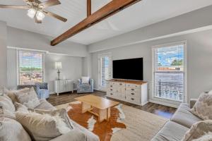 a living room with a couch and a flat screen tv at Penthouse Loft- Balcony Over Downtown Statesboro in Statesboro