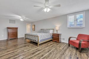 a bedroom with a bed and a chair and a ceiling fan at Penthouse Loft- Balcony Over Downtown Statesboro in Statesboro