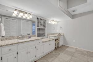 Baño blanco con 2 lavabos y espejo grande en Penthouse Loft- Balcony Over Downtown Statesboro, en Statesboro