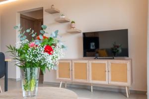 a vase of flowers sitting on a table in a living room at Terra Blue Suites - Dimitra in Kalyves