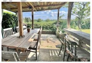 ein Holztisch und Stühle auf einer Terrasse in der Unterkunft Chelmsford Cottage Homestay Free Parking Fab Garden in Great Waltham